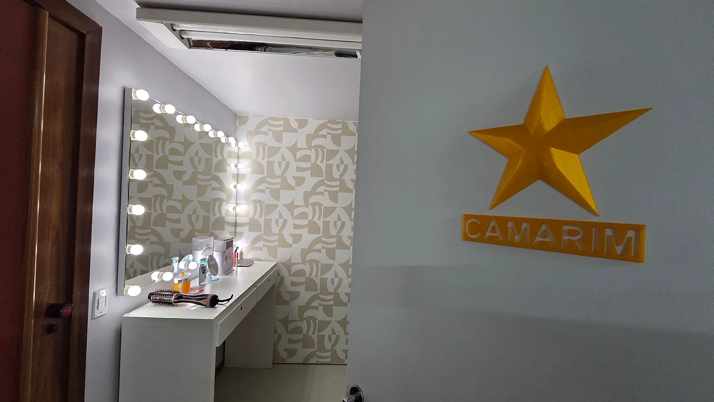 Camarim do estúdio com espelho iluminado e bancada