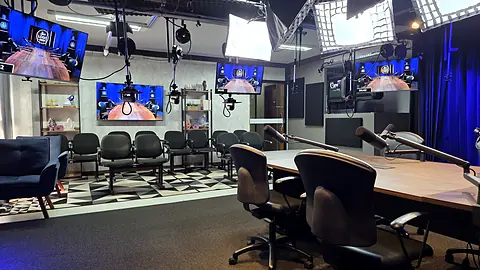 Estúdio em configuração de transmissão com câmeras, monitores e iluminação